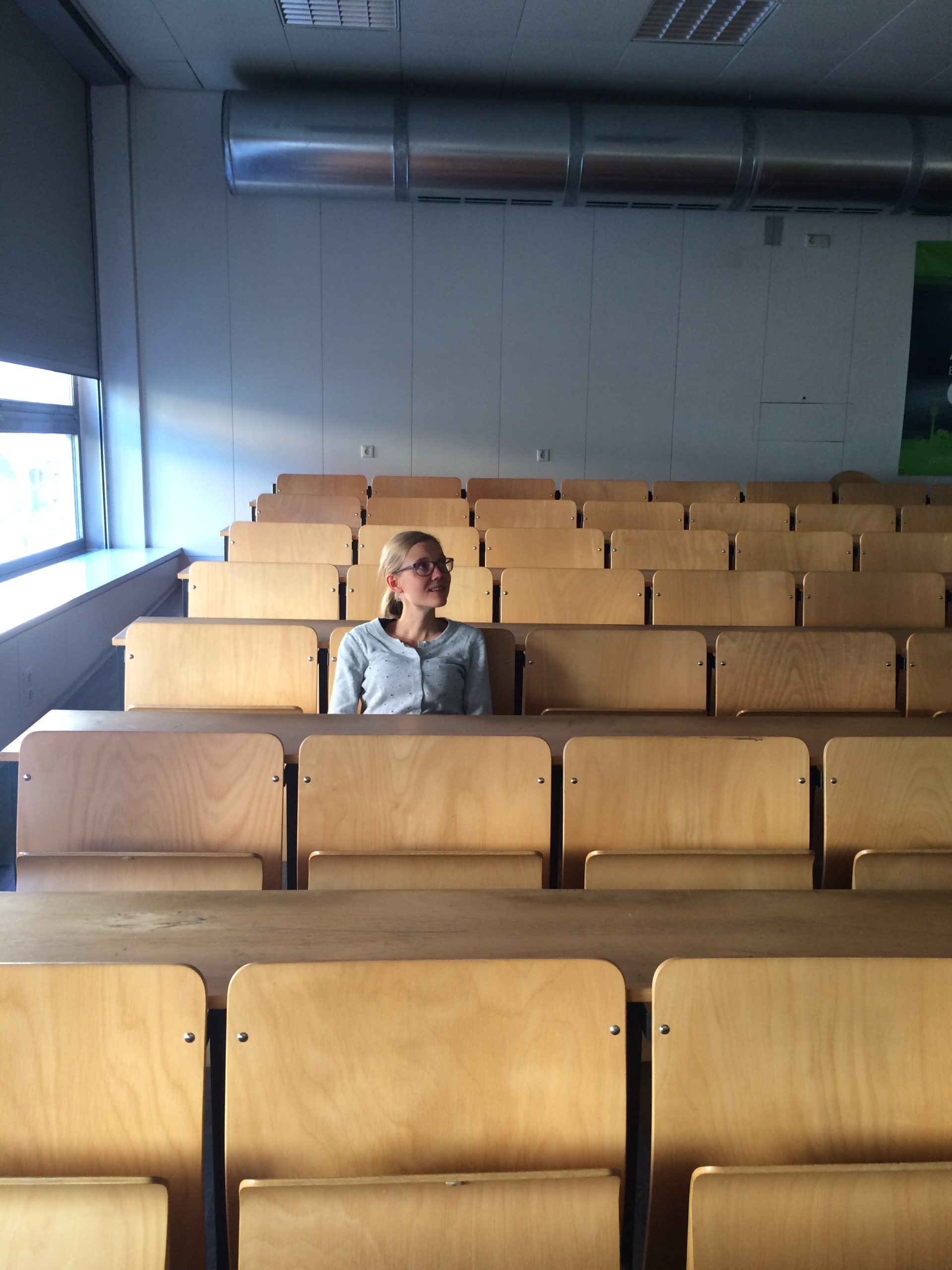 Anna in einem leeren Hörsaal Anna beim Vortrag